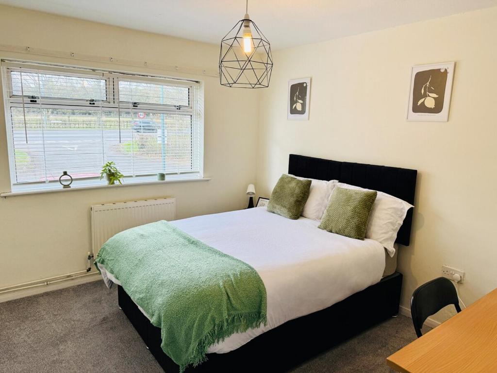 a bedroom with a bed and a table and a window at Professional 4BR House - Lace Market, Uni, QMC, City Centre & M1 - Sleeps 8 in Nottingham