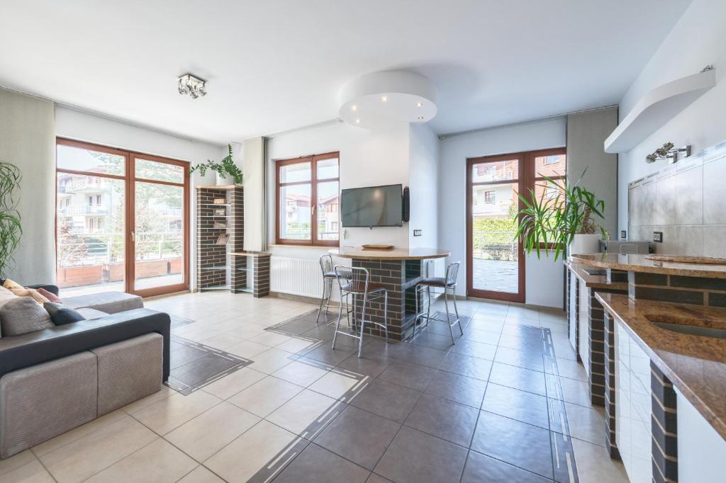a living room with a couch and a table at Neptun Park by NorthSide Apartments in Gdańsk