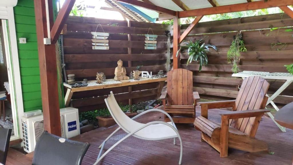 a patio with two chairs and a table on a deck at Gites d'Arles Bungalow T1 BIS in Le Moule