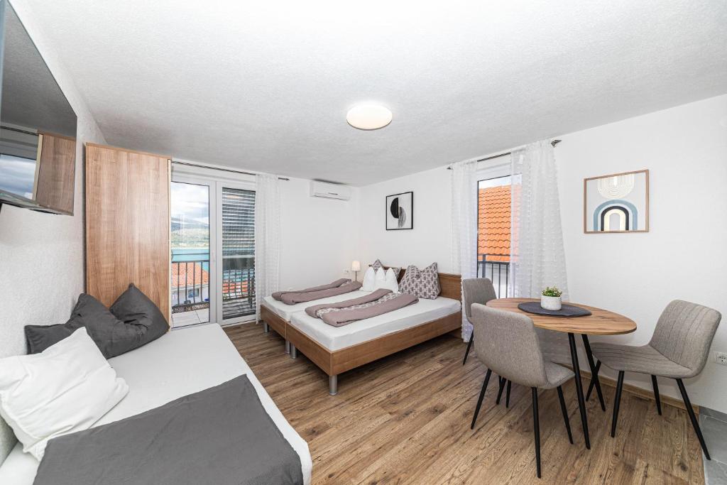 a bedroom with a bed and a table and chairs at Apartman Simic in Trogir