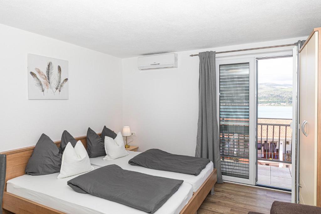 a bedroom with a bed and a balcony at Apartman Simic in Trogir