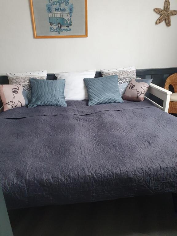 ein Bett mit einer lila Decke und Kissen darauf in der Unterkunft La Maison de Jeanne in Lesparre-Médoc