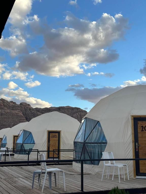 a row of domes with chairs in front of them at Lucas Camp Wadi Rum in Disah