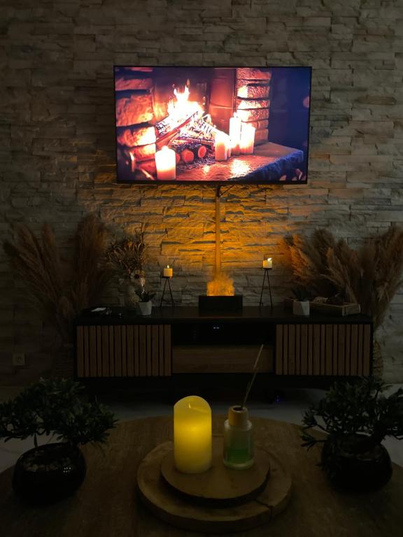Una sala de estar con chimenea y televisión. en BY NEPTUNE - Appartement Rustique JACUZZI, en Bondy