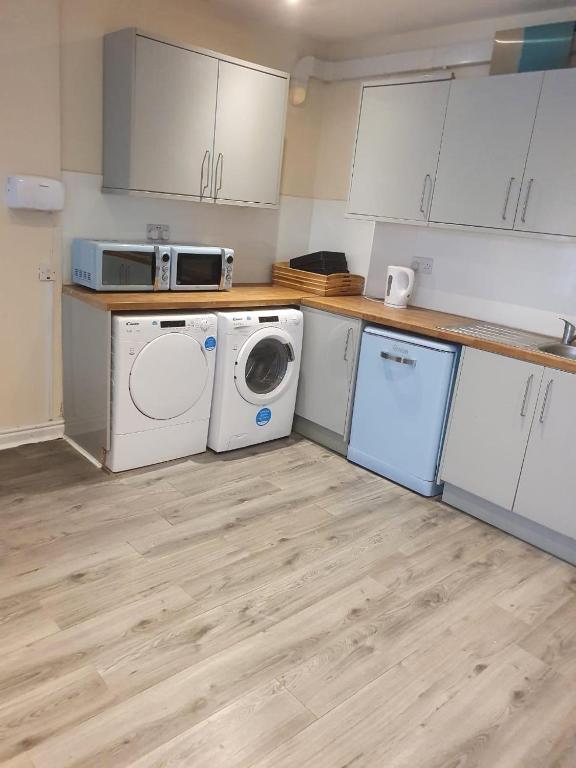 a kitchen with a washing machine and a washer and dryer at Heavenly Apartment in Woodside