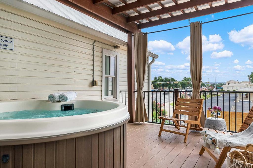 a jacuzzi tub in a room with a balcony at Enchanted Haus walk to Main hot tub on balcony in Fredericksburg