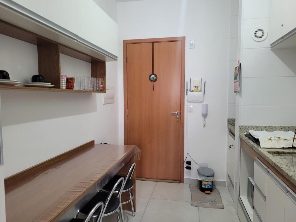 eine Küche mit einer Theke und einer Holztür in der Unterkunft Espaço São Rafael Arcanjo in Cachoeira Paulista