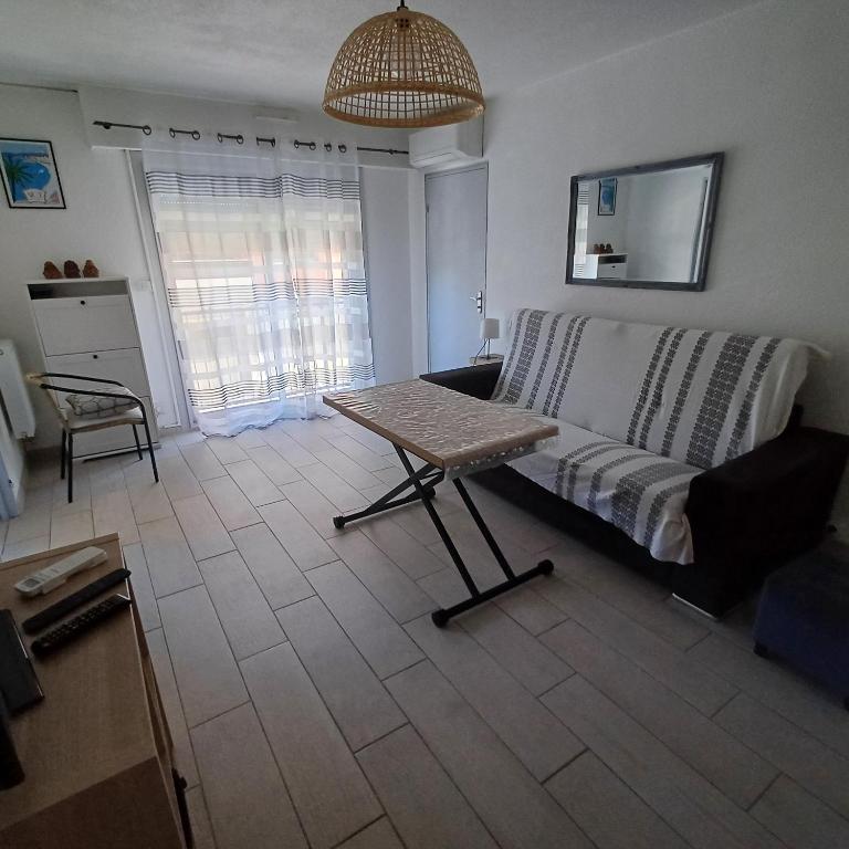 un salon avec un canapé et une table dans l'établissement F1 à 5 minutes des plages et de la gare, à Vallauris