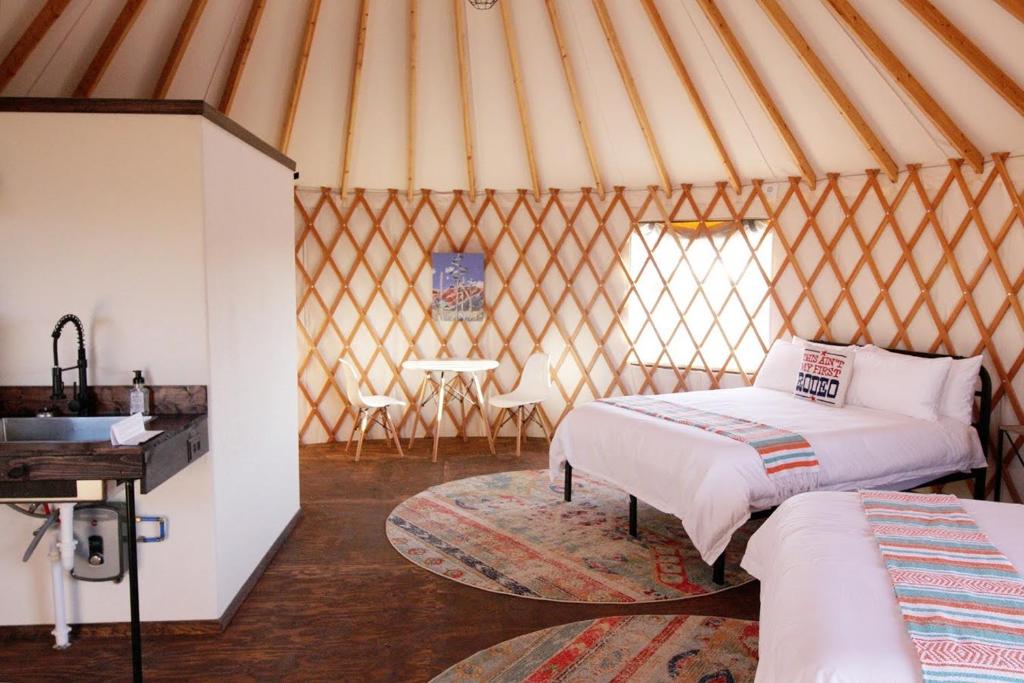 ジョンソンシティにあるJohnny Yurts - The Rodeoのパオとベッド2台、テーブル