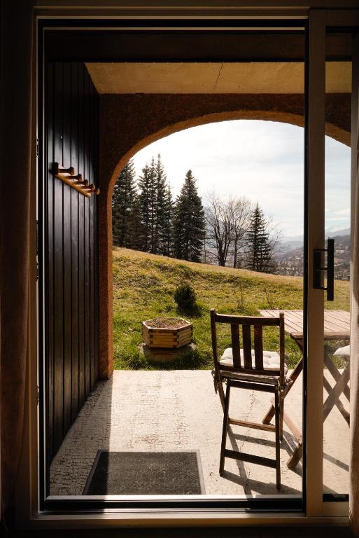 une porte avec un banc assis sur un porche dans l'établissement Appartement très calme 2 chambres avec parking et jardin privé sur les hauteurs de Briançon, à Briançon