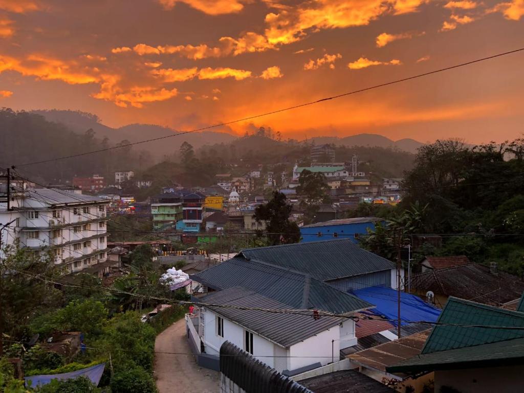 a view of a city at sunset at Birdwing Cottage, Munnar in Munnar