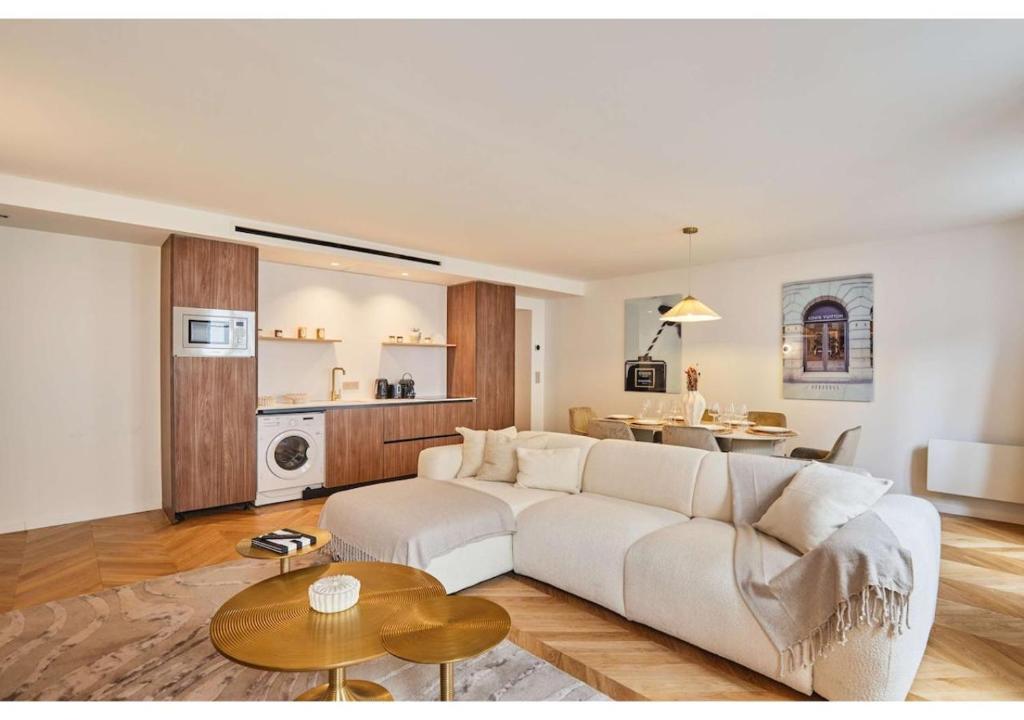 un salon avec un canapé blanc et une table dans l'établissement Sublim AC Apartment Opéra Madeleine, à Paris