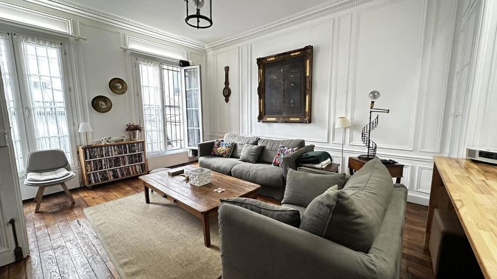 un salon avec un canapé et une table dans l'établissement Chic 1 room apartment Near Louvre & Palais Garnier, à Paris