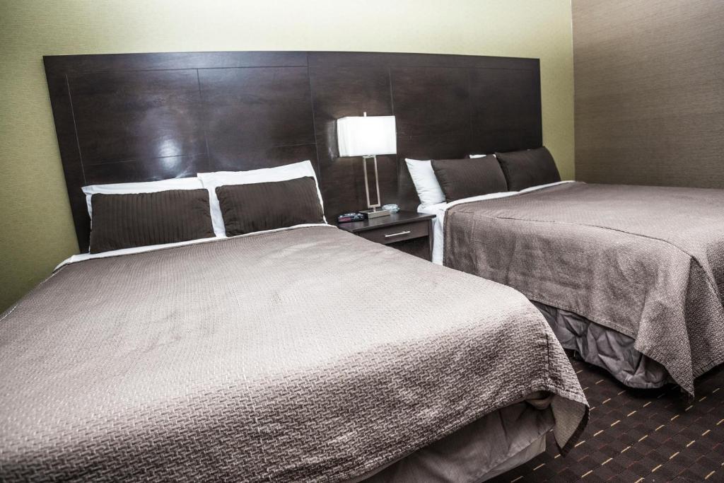 Postel nebo postele na pokoji v ubytování Mississauga Gate Inn