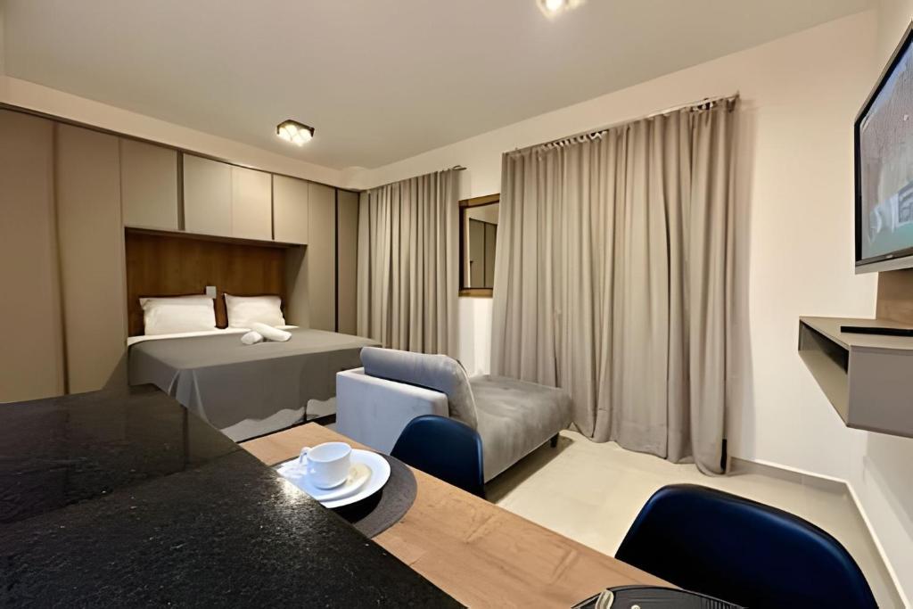 a hotel room with a bed and a table and chairs at Studio Duo Jk Panorama 4 in Sao Jose do Rio Preto