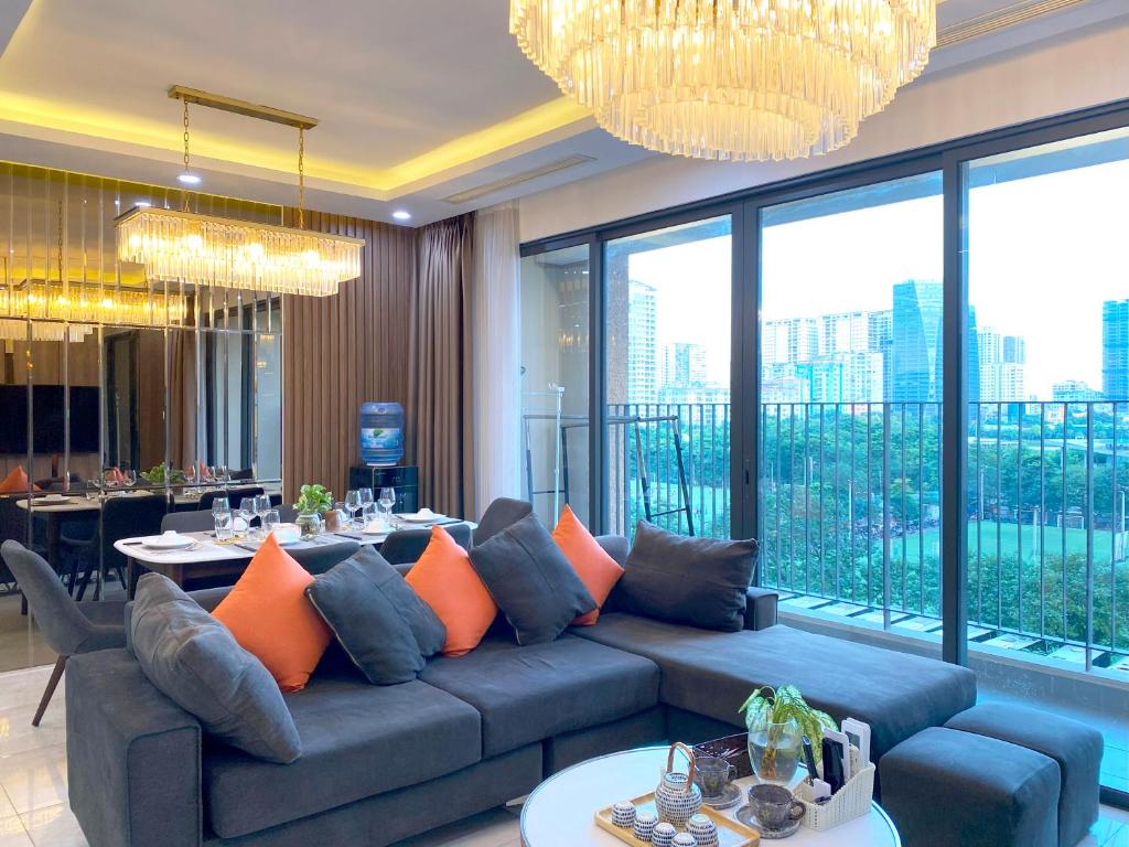 un salon avec un canapé avec des coussins orange dans l'établissement QMP - Vinhomes D'Capitale Tran Duy Hung, à Hanoï