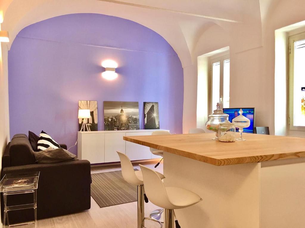 een woonkamer met paarse muren en een tafel bij Sole Mio in Sanremo