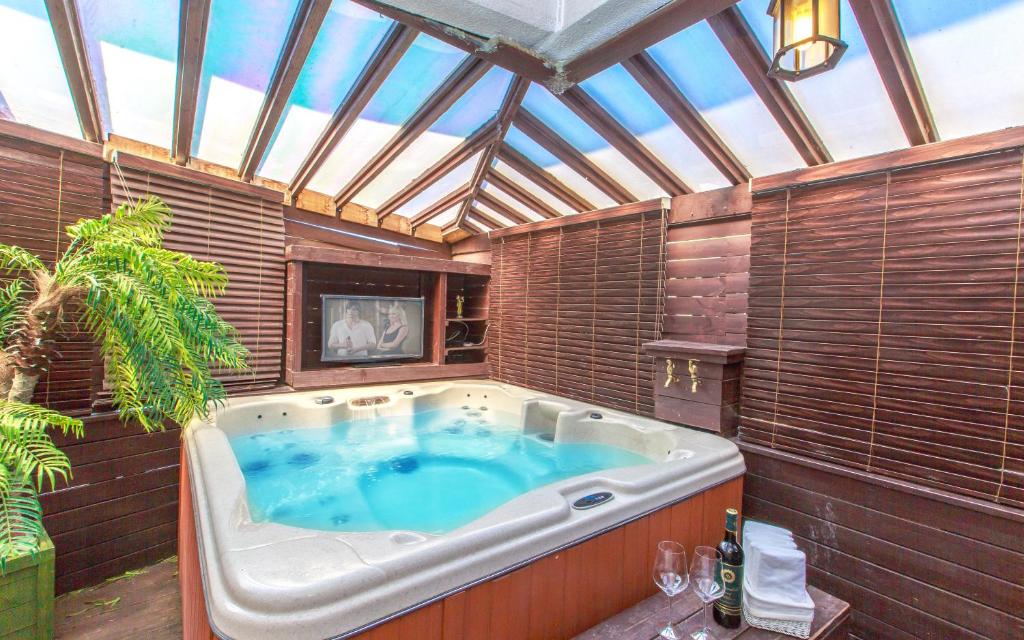 a jacuzzi tub in a room with a roof at Spa Pension Basso in Sokcho