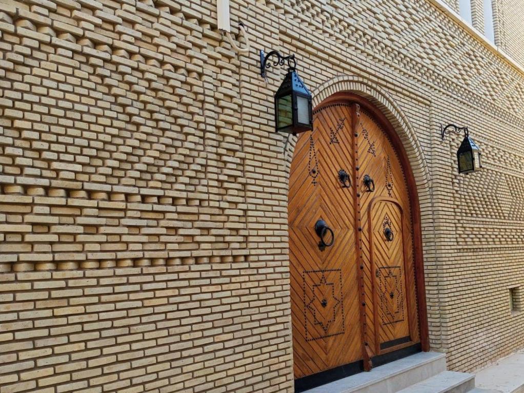 a large wooden door on a brick building at Dar Desert Rose in Nefta