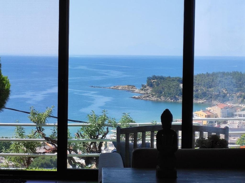 a person looking out a window at the ocean at AEGEAN view ! in Kavála