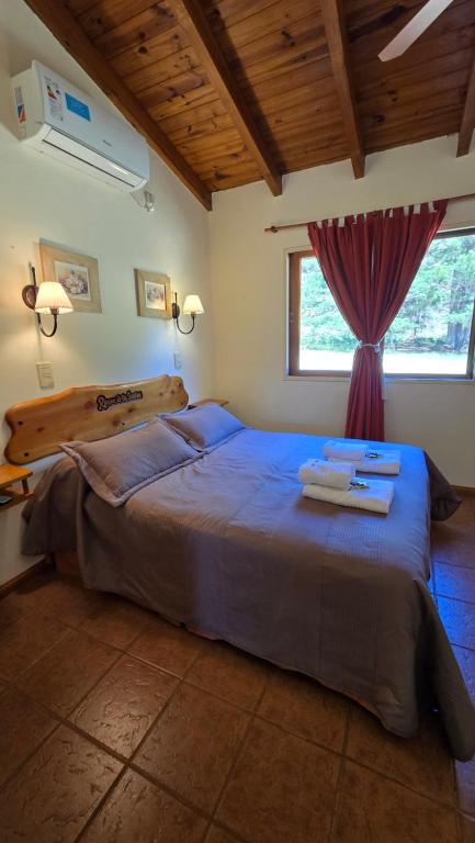 a bedroom with a large bed and a window at Rincón de los Sueños in Villa General Belgrano