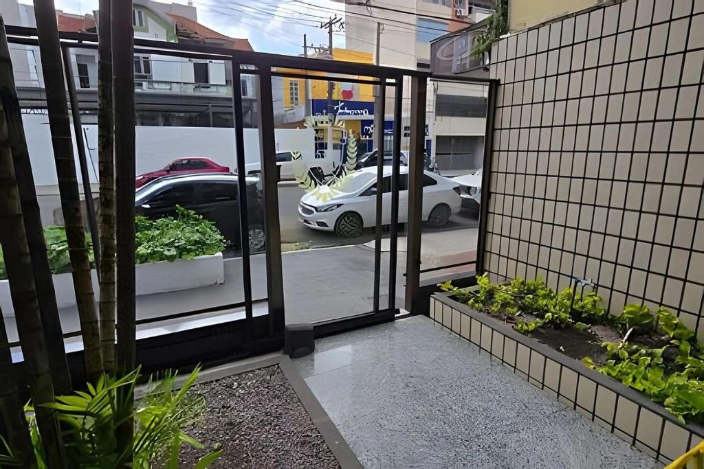 an open door to a parking lot with a car outside at Ed. Delta Gardenn in Carmo
