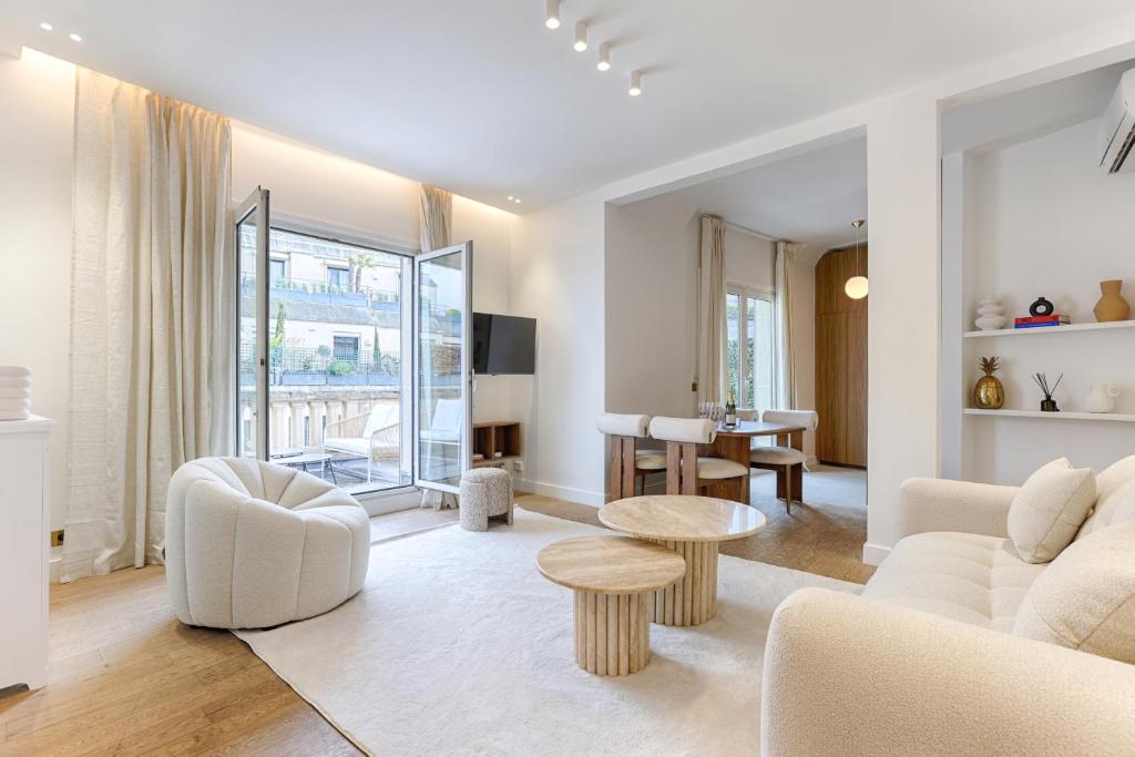 un salon avec des meubles blancs et une table dans l'établissement Appartement de Luxe avec terrasse sur les Champs Elysées, à Paris