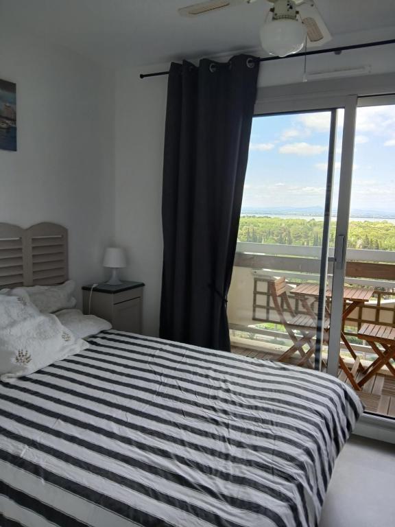 une chambre avec un lit et une grande fenêtre dans l'établissement Appartement Entre port et mer haut standing, à La Grande Motte