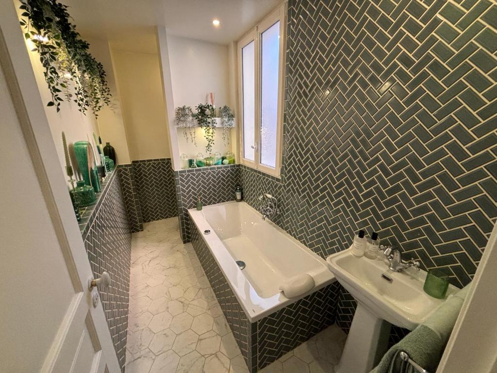 une salle de bain avec une baignoire et un lavabo dans l'établissement Appartement design avec terrasse, à Boulogne-Billancourt