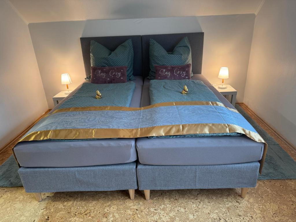 a large bed in a bedroom with two lamps at Fewo Naturblick in Wiesenthau