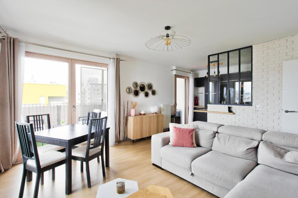 un salon avec un canapé et une table dans l'établissement Chill 2 à Paris La Défense Arena, à Nanterre