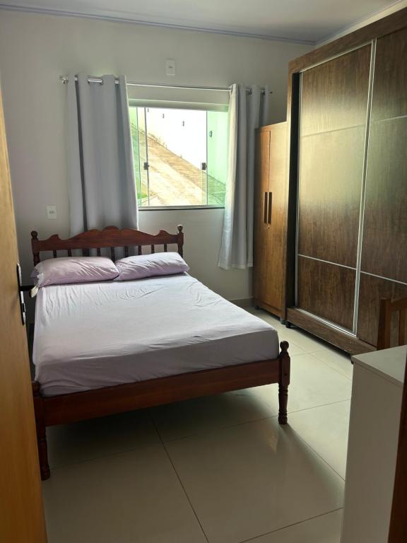 un letto in una stanza con una finestra e un letto sidx sidx sidx di Casa melo a Pirenópolis