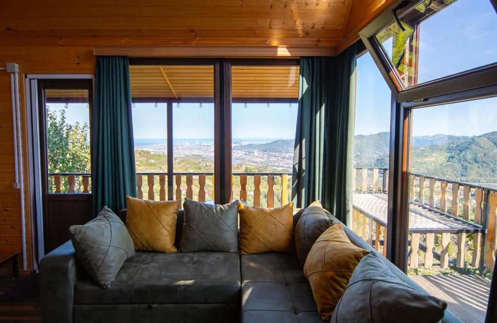 a couch in a living room with a large window at chemi kera Chalet in Makho