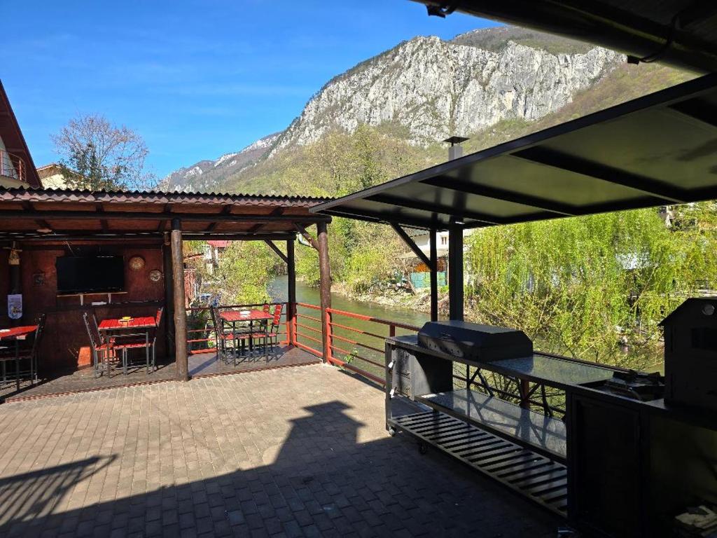 a patio with a table and a view of a mountain at Casa Vivian in Băile Herculane