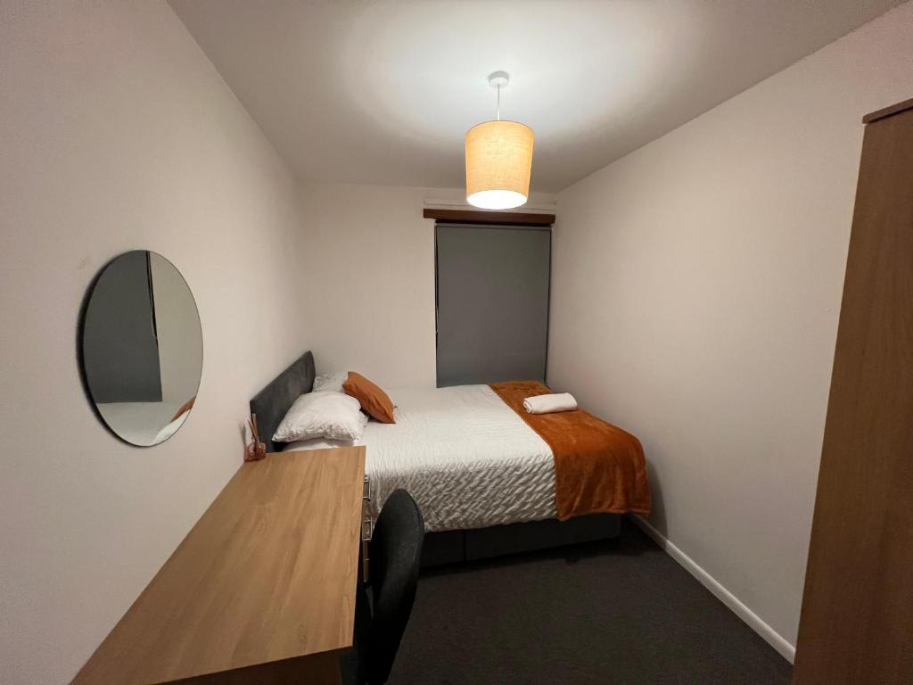 a small bedroom with a bed and a mirror at The Coral Guest House 1 Mile from Winchester Market in Winchester