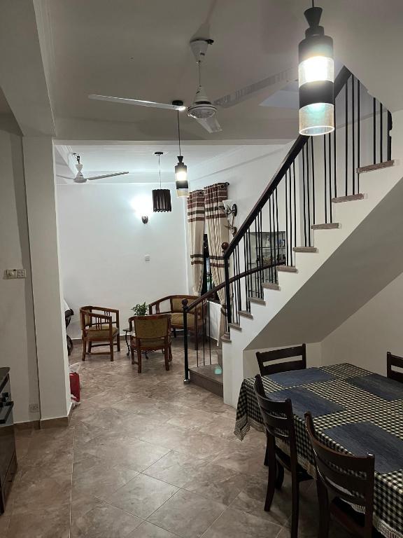 a dining room with tables and chairs and a staircase at Colombo Green Heaven in Cotta Road Railroad Station