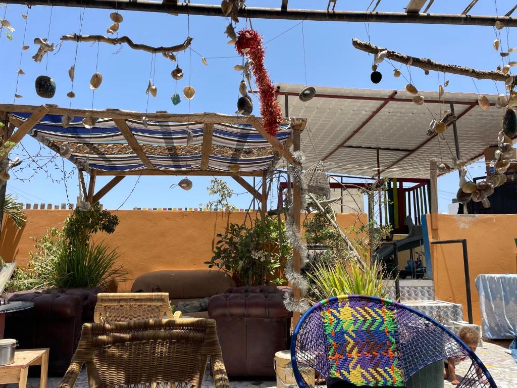 a patio with a canopy and chairs and plants at Fadidi House in Dakar