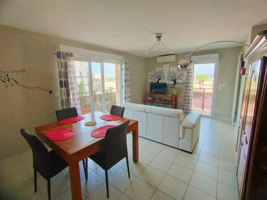 une salle à manger et un salon avec une table et des chaises dans l'établissement PARVIS : Calme, vue, élégant, spacieux, sécurisé et central, à Agde