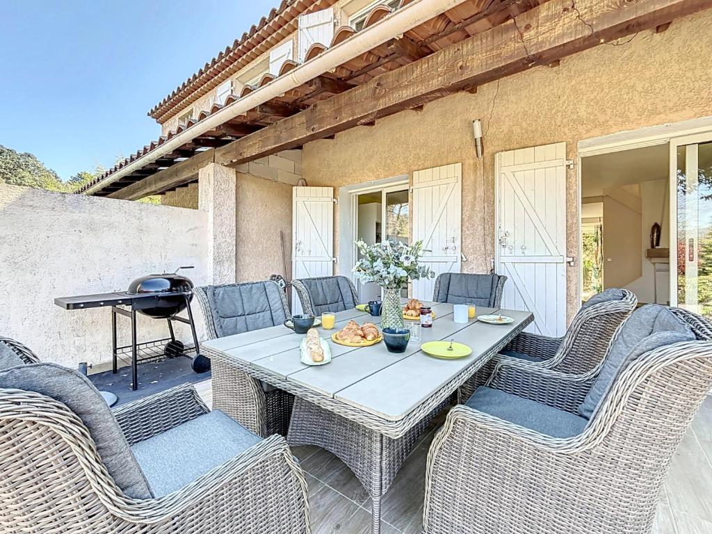 un patio avec une table, des chaises et un barbecue dans l'établissement Villa Cosy Valbonne - jardin privé et piscine partagée, à Valbonne