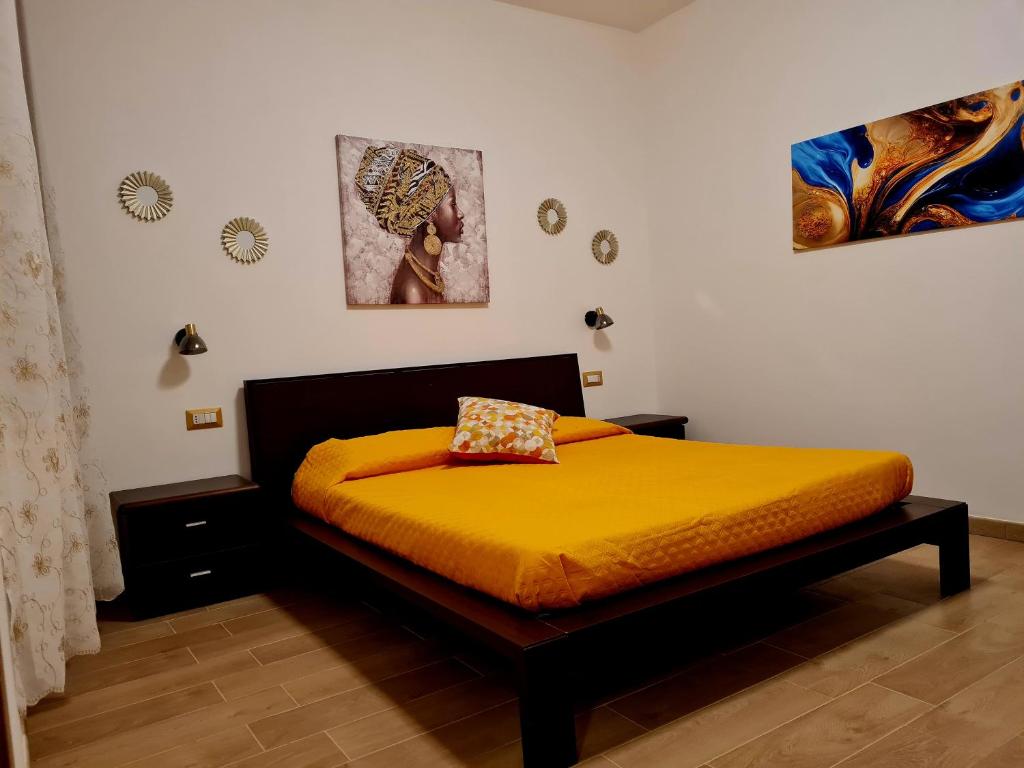 a bedroom with a bed with a yellow bedspread at B&b Tre Pandele in Ploaghe