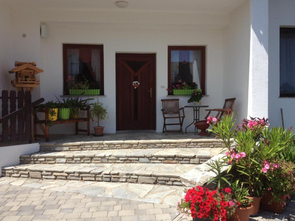 a patio with a wooden door and a table with flowers at Pension Anna in Rust