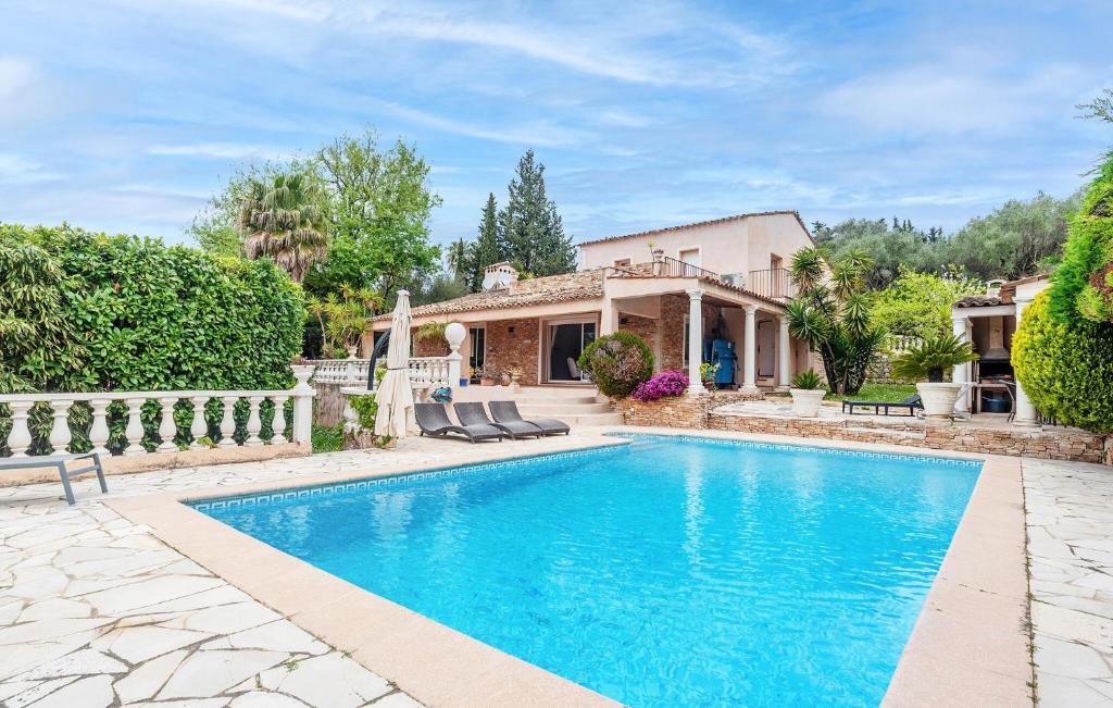 a home with a swimming pool and a house at Beautiful Home In Mougins in Mougins