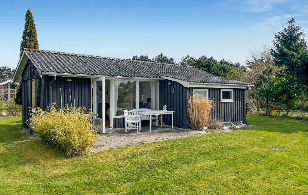 a blue shed with a picnic table in a yard at 2 Bedroom Lovely Home In Dannemare in Dannemare