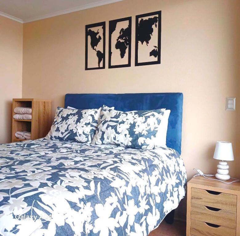 une chambre avec un lit avec une couette bleue et blanche dans l'établissement Departamento Osorno centro, à Osorno