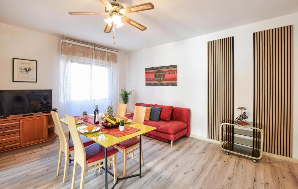 a living room with a table and a red couch at 1 Bedroom Lovely Apartment In Grado in Grado
