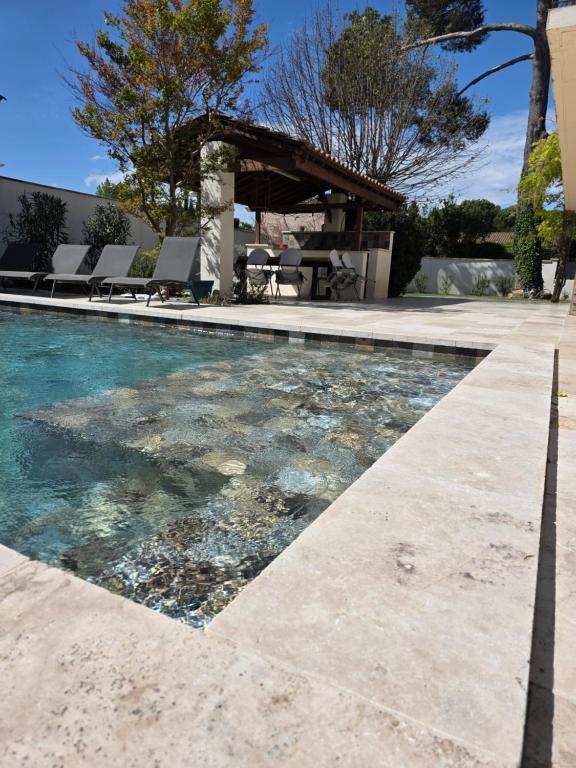 - une piscine avec des rochers dans l'eau dans l'établissement Villa MOOREA pool barbecue PROVENCE, à Entraigues-sur-la-Sorgue