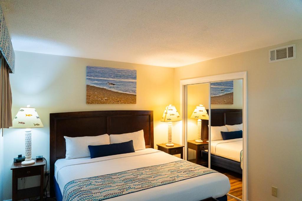 a hotel room with a bed and a mirror at Summer Sands - 303 by Sea Scape Properties in Wrightsville Beach