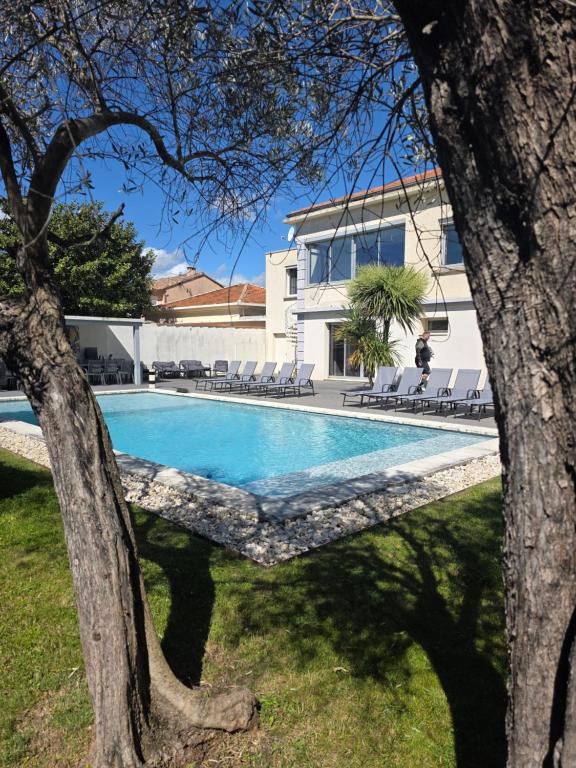une piscine devant une maison dans l'établissement Villa LEONIE piscine clim 5 chambres 1 dortoir 15 PERSONNES, à Avignon