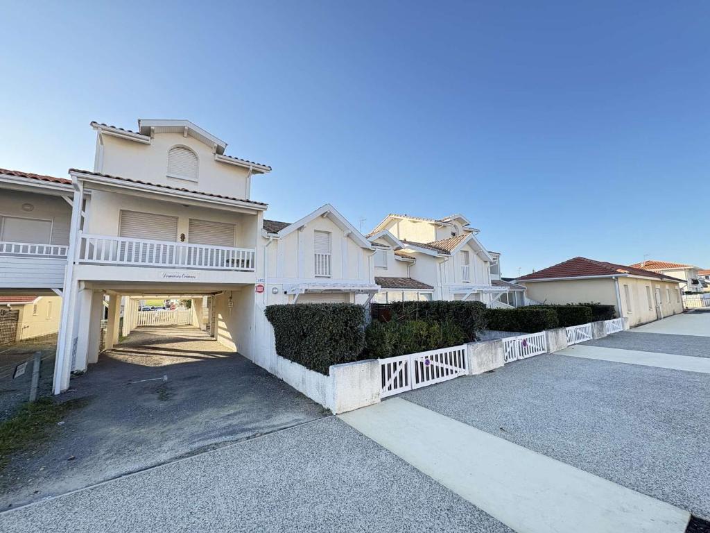a row of white houses with a driveway at Cadre idéal près de l'océan pour 4 personnes à Biscarrosse Plage - FR-1-831-6 in Biscarrosse