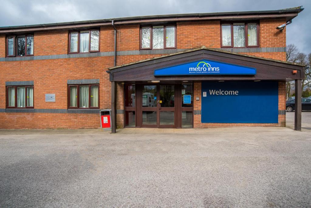 a building with a welcome sign in front of it at Metro Inns Huddersfield in Huddersfield